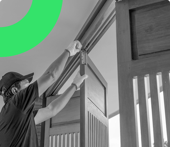 A male installation expert fitting bi-fold doors in a customer's home