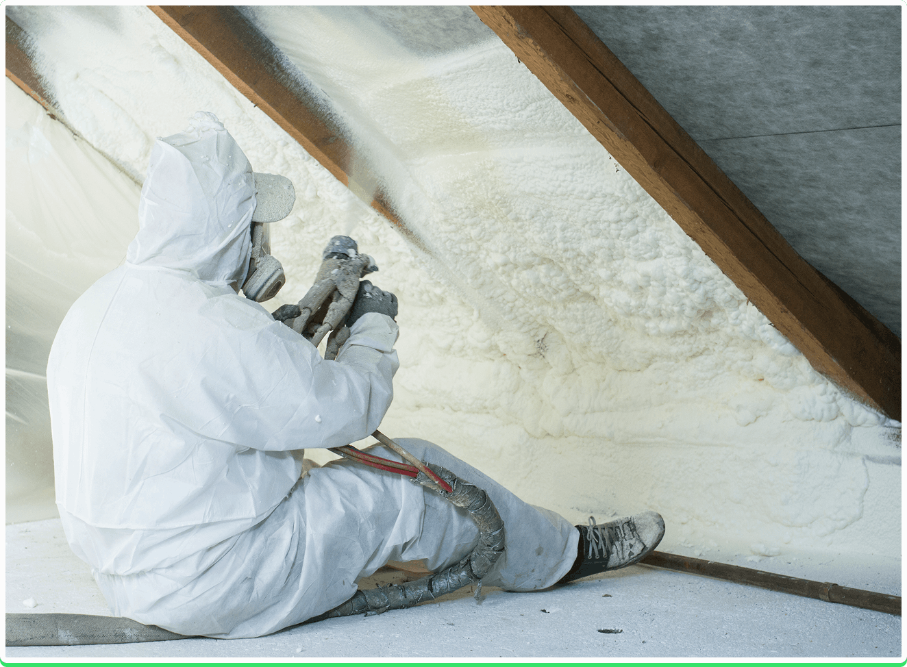 A spray foam insulation removal technician dressed in protective gear, expertly removing spray foam from a homeowner's loft walls
