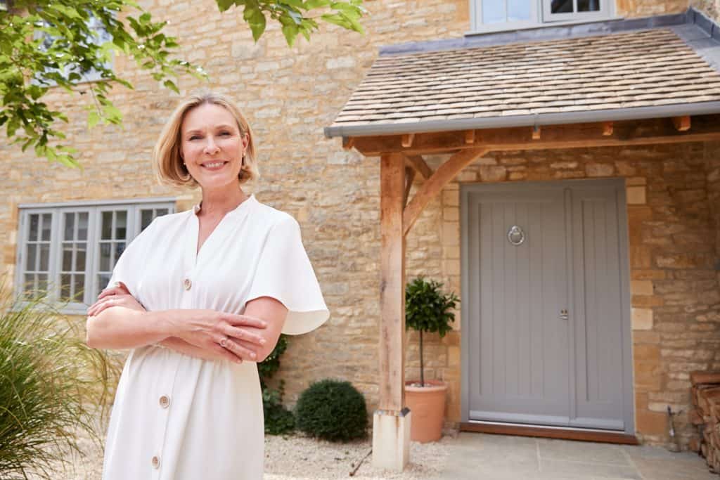 Smiling woman standing outside door of home